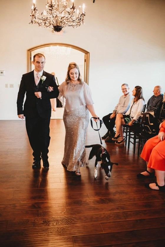 bridesmaid walking down the aisle with a pup