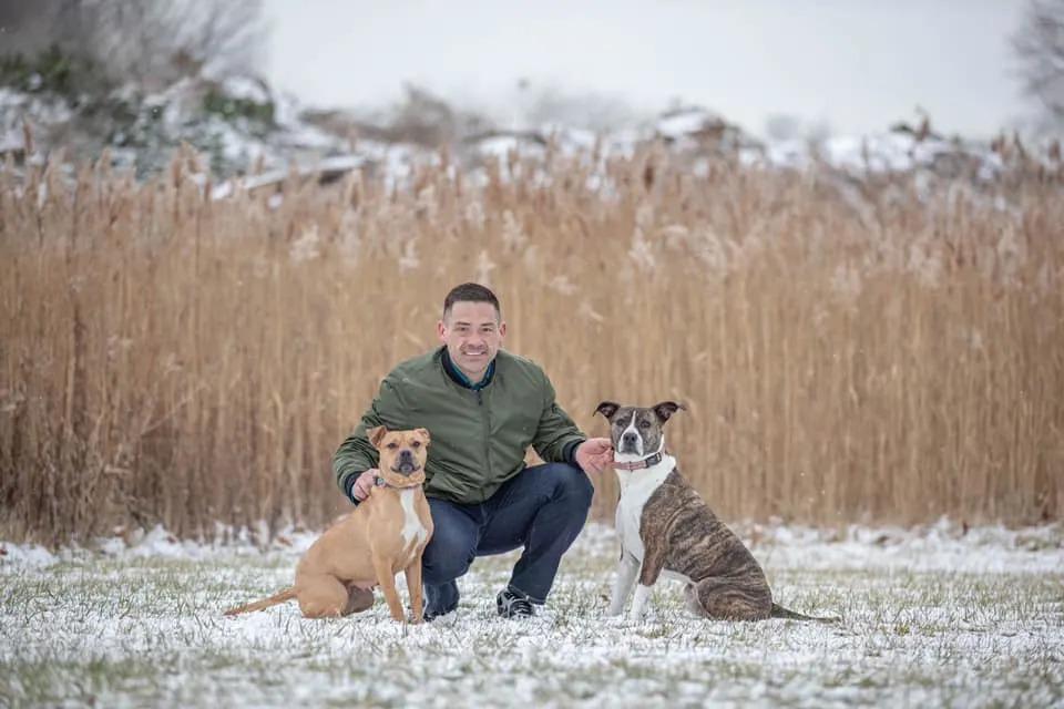 man with two dogs in the snow