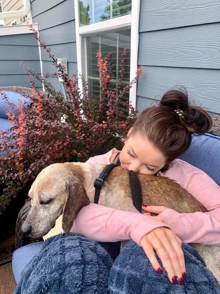 woman cuddling with dog