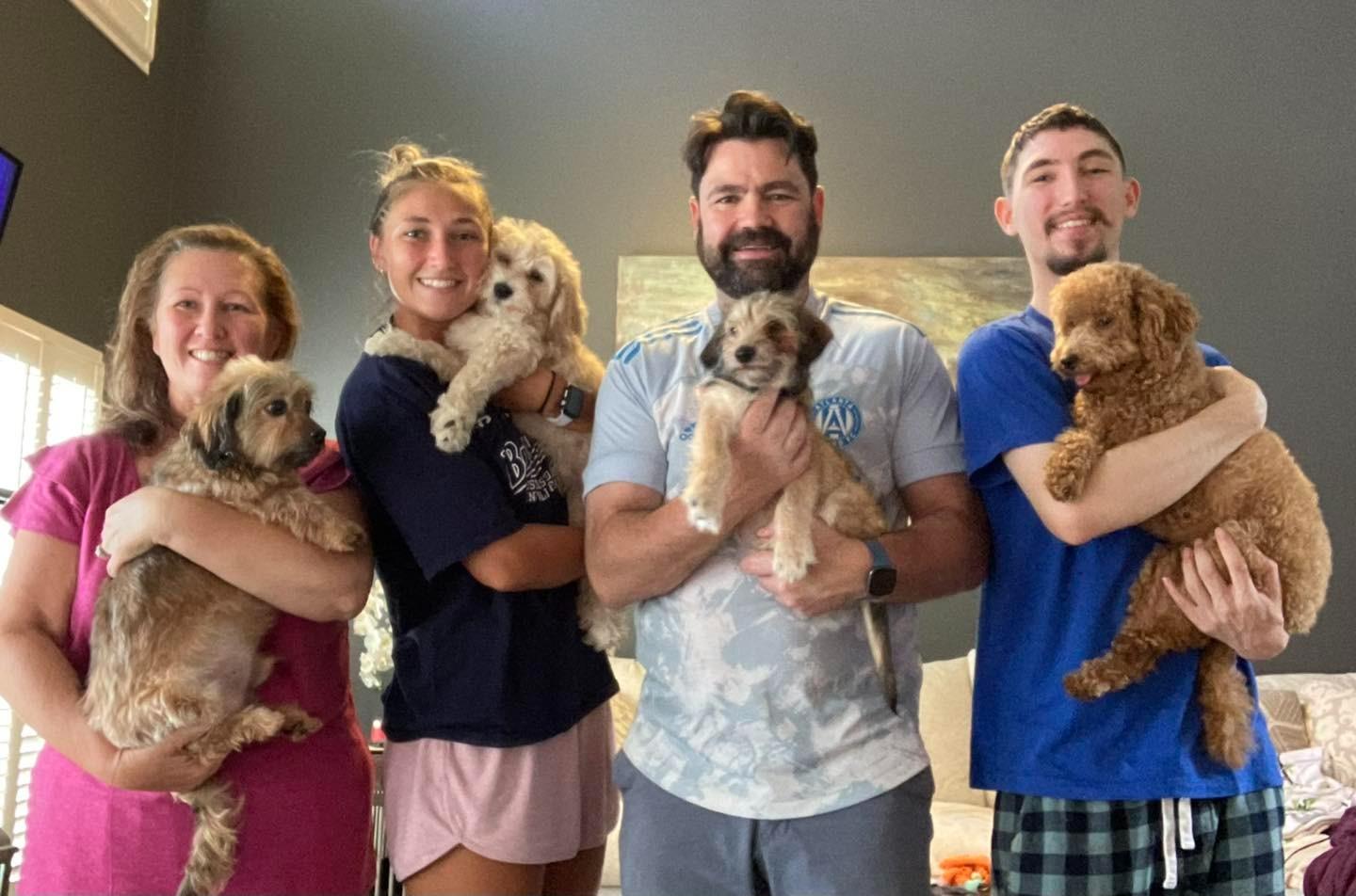 group of people holding pups in their arms