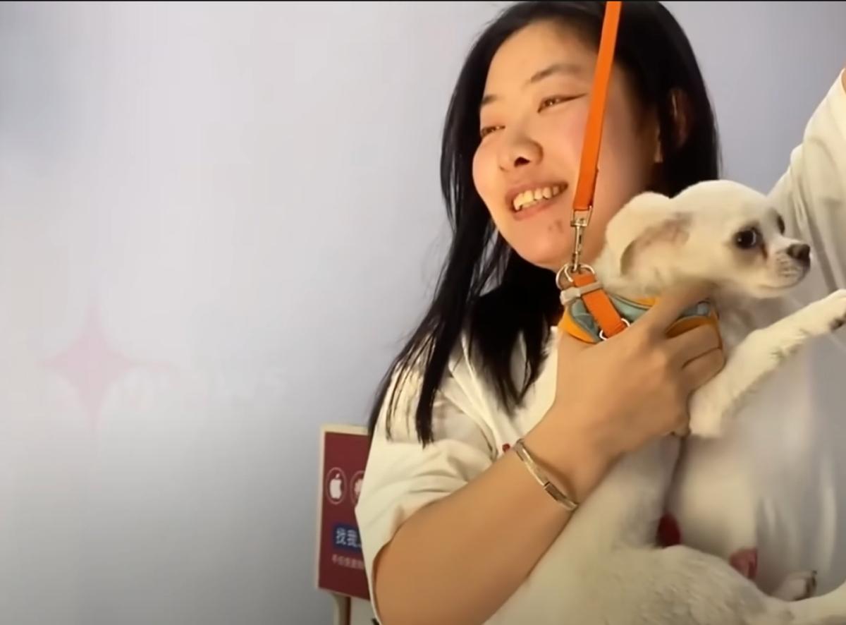 kind woman holding a small white pup