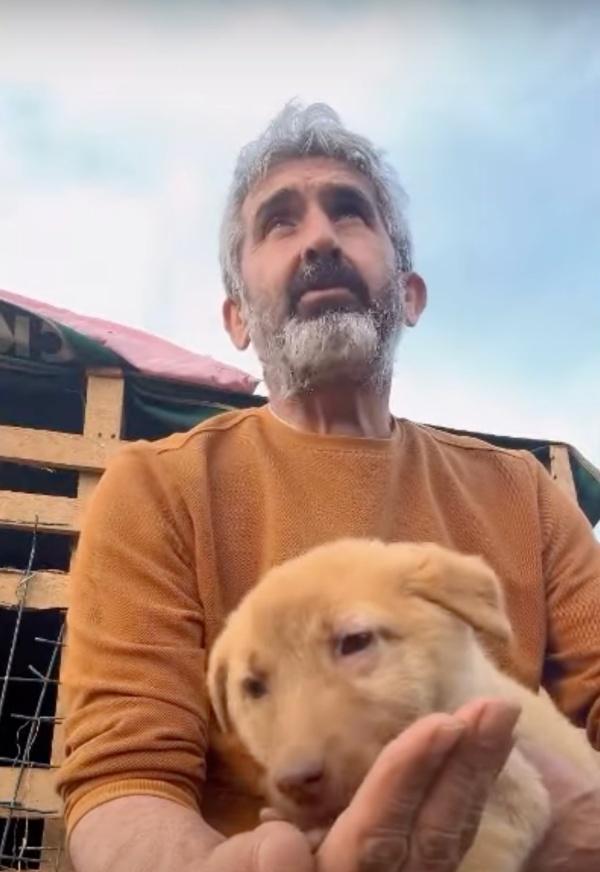 man giving food to a pup from his hand
