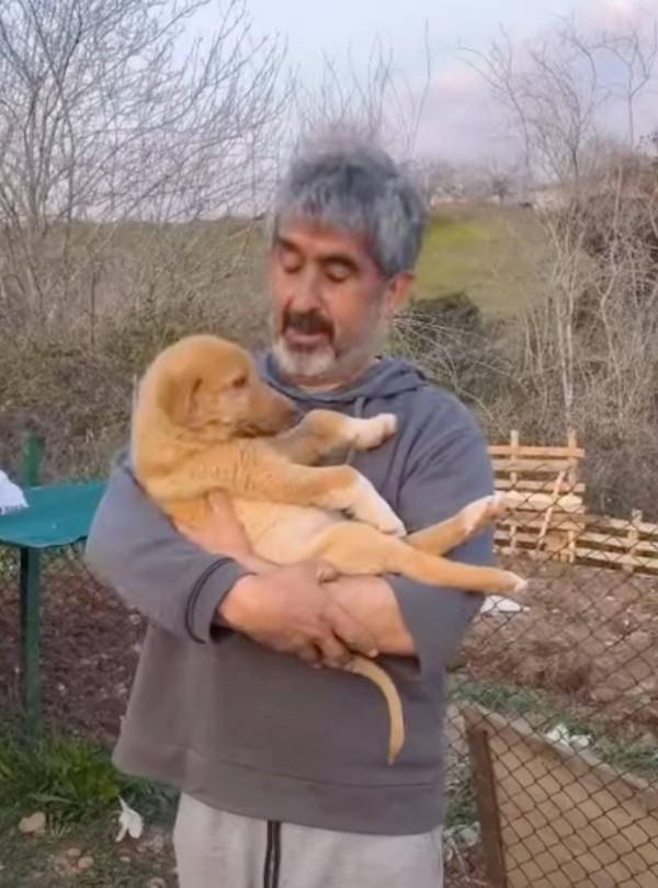 man holding a pup like a baby